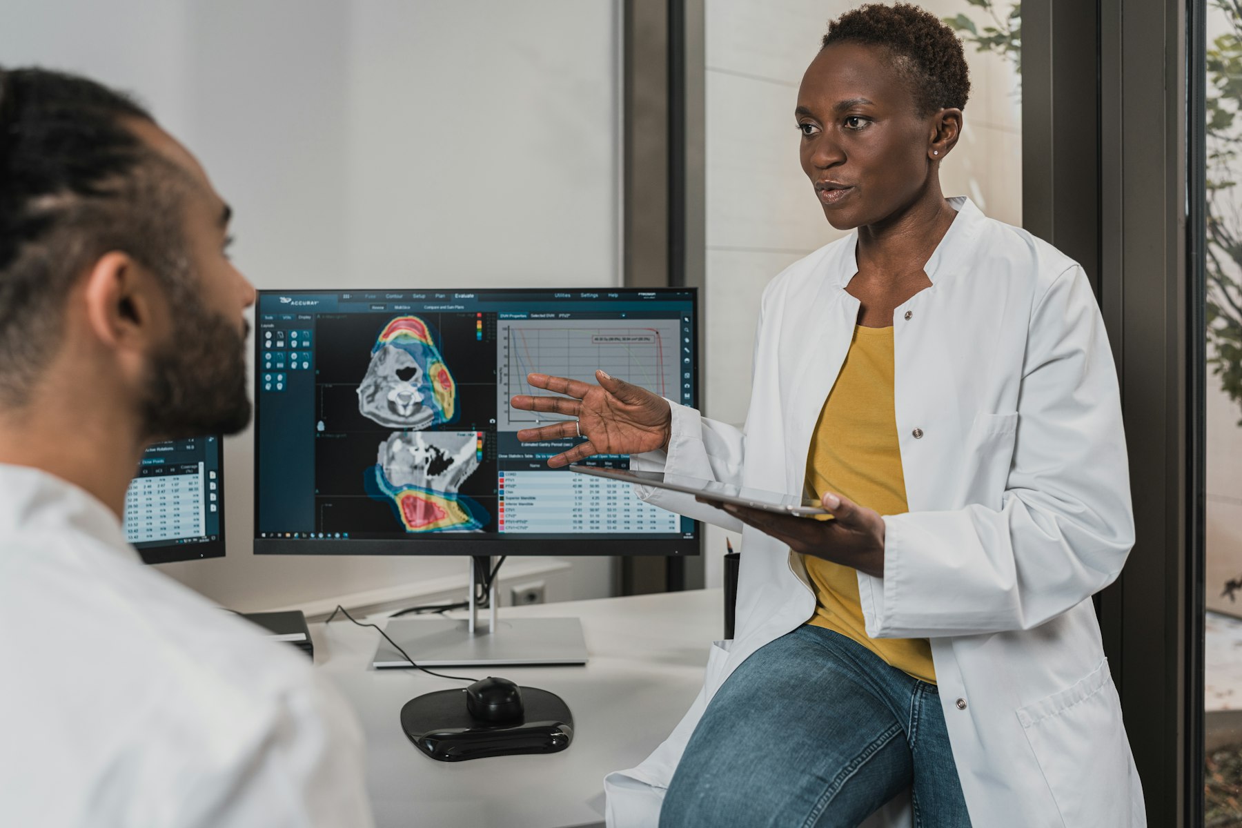 Two clinicians reviewing scans together at a workstation